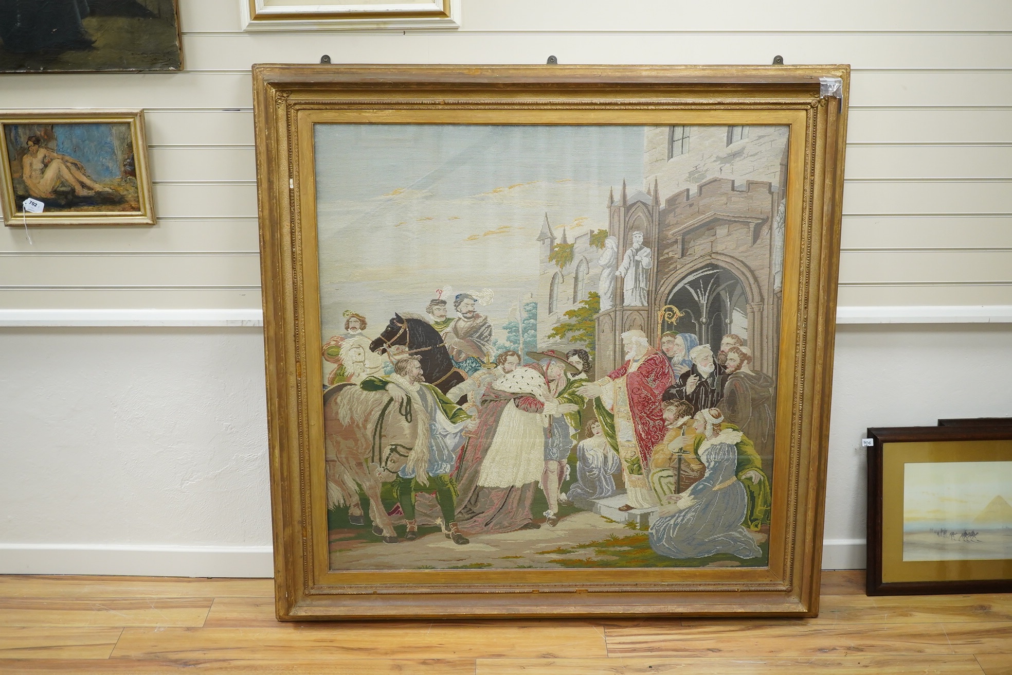 A large gilt framed English 19th century Berlin wool work, in mixed gross point and petit point, the embroidery a medieval scene of Cardinal Wolsey meeting the Archbishop of Canterbury and many courtiers and attendants o